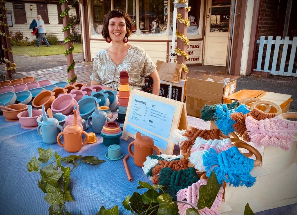 Anna with Mala’s Meals dinnerware and toys at a local market