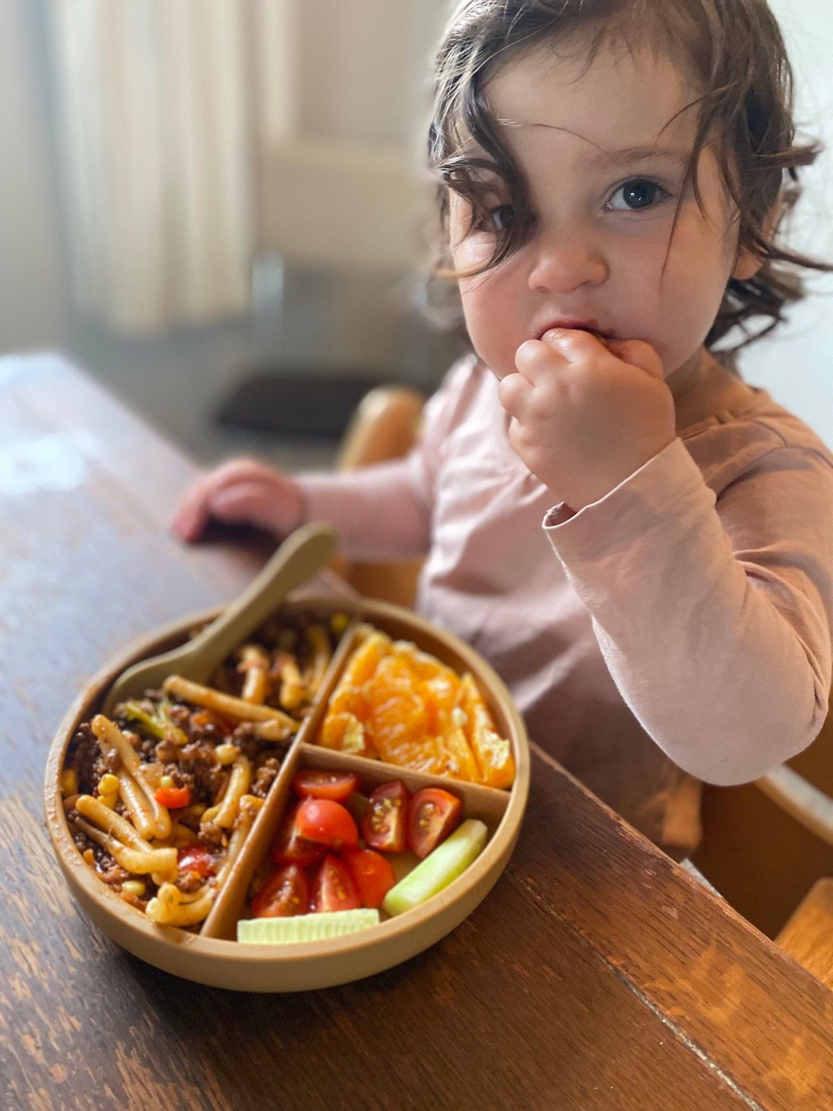 A young child enjoying a colourful meal