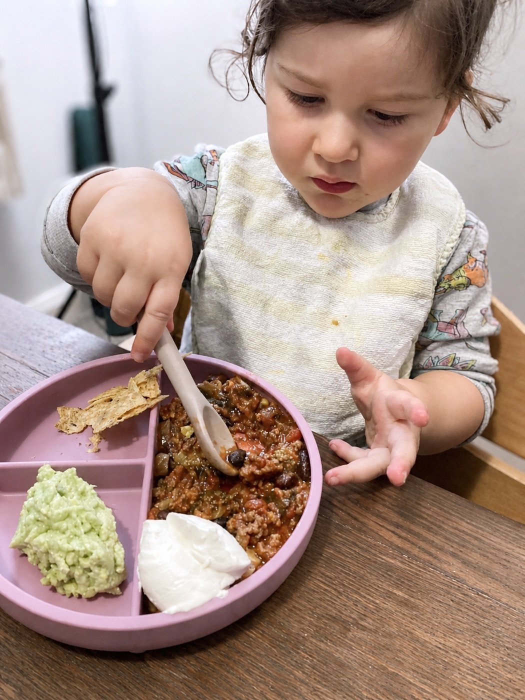 A young child practising independent eating
