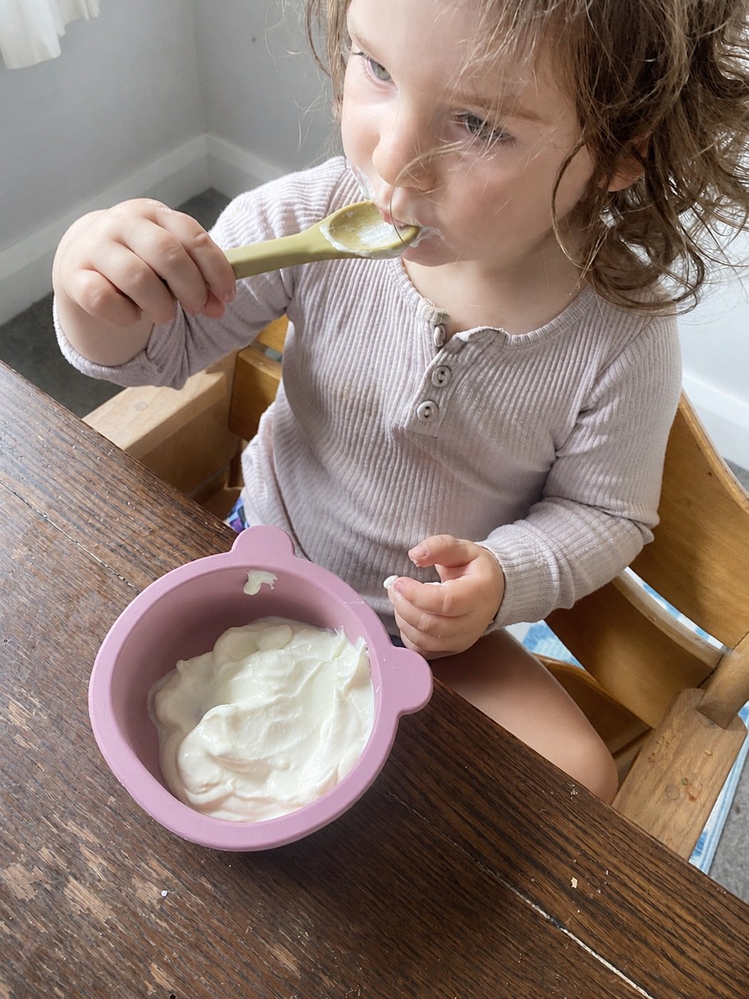 A pink silicone bowl being used at mealtime